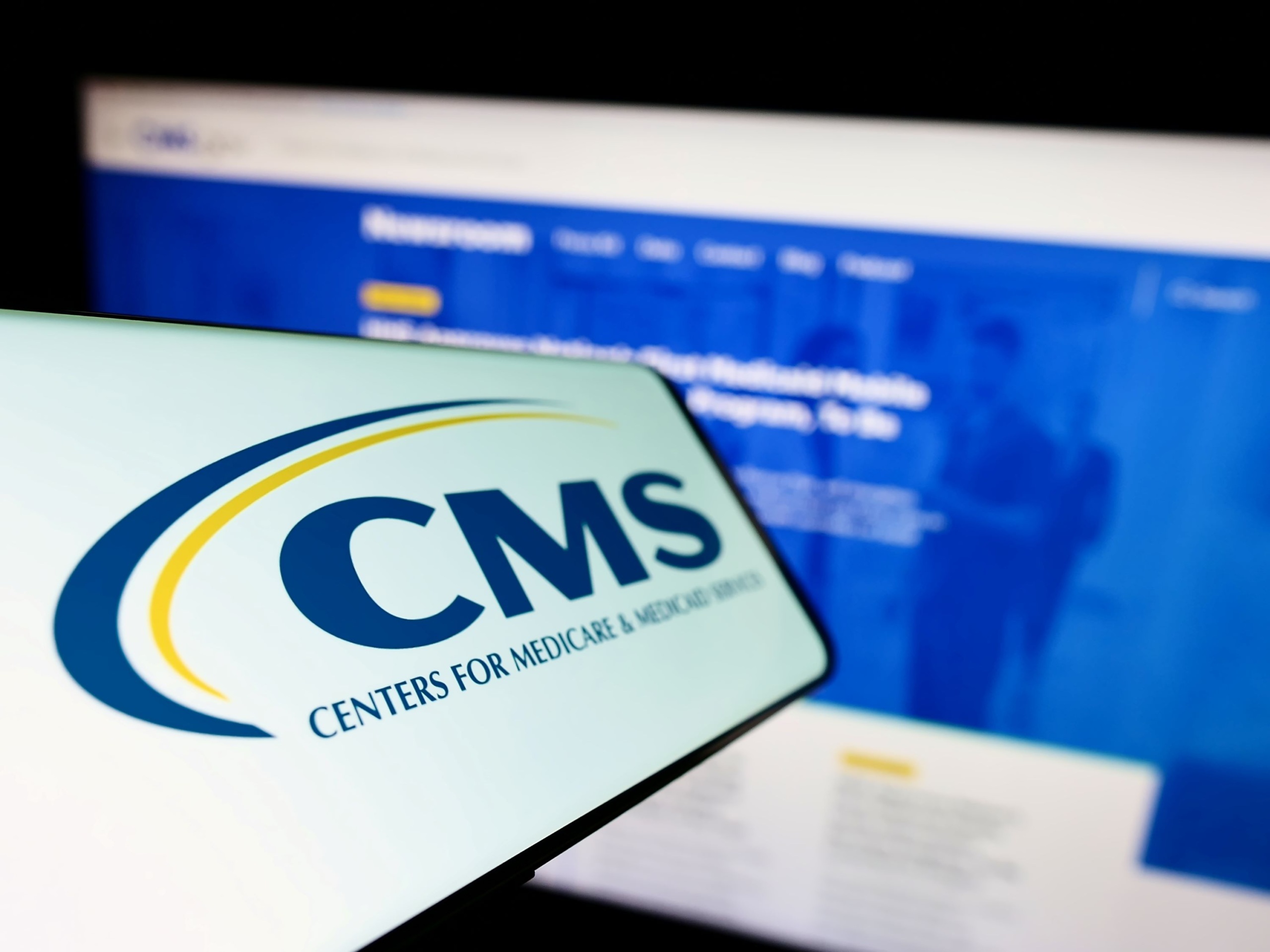 Smartphone and computer displaying CMS logo and CMS.gov webpage