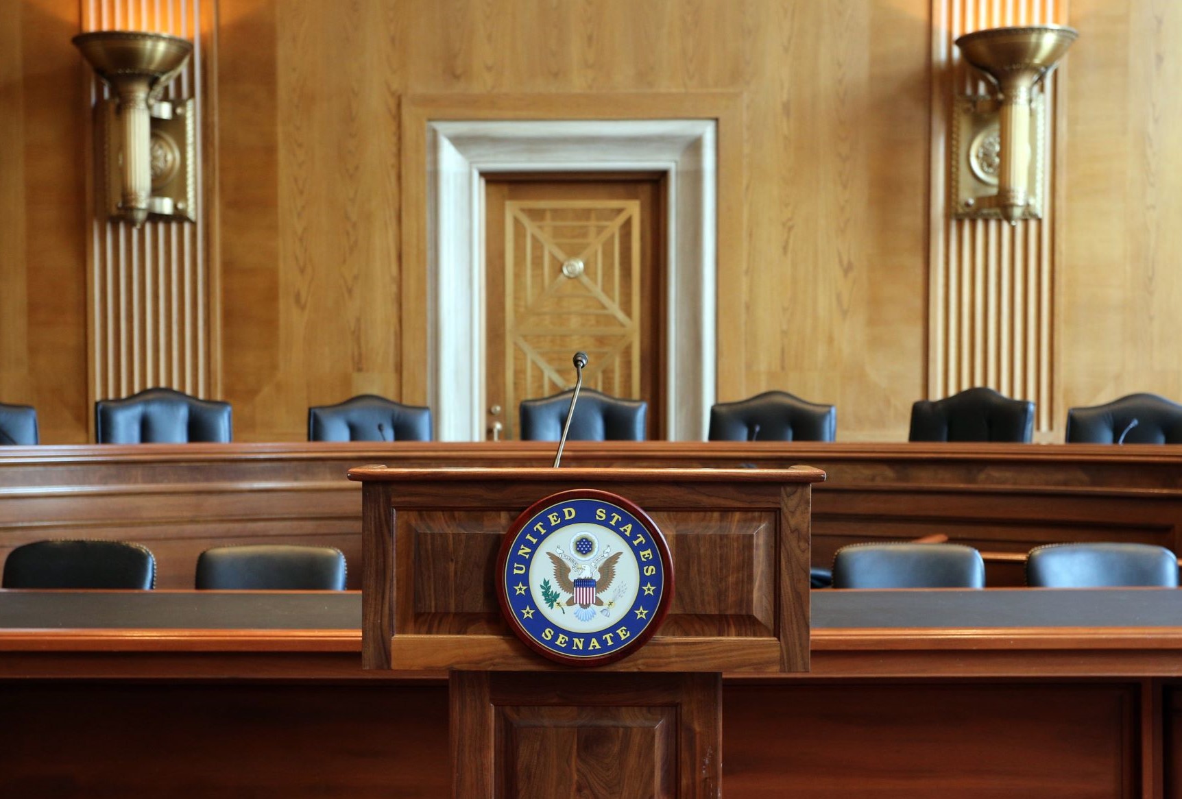 Podium in congressional hearing room with the seal of the U.S. Senate